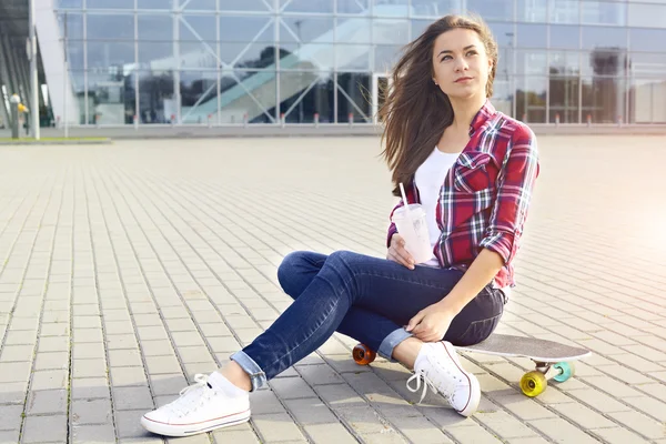 Krásná mladá žena s skateboard a koktejl — Stock fotografie