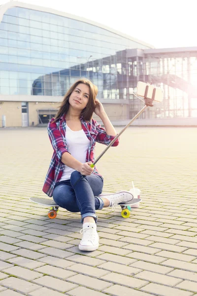 Skateboardista holka dělat selfie s holí — Stock fotografie