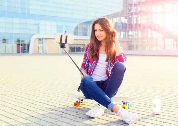 Bella giovane donna con uno skateboard — Foto Stock
