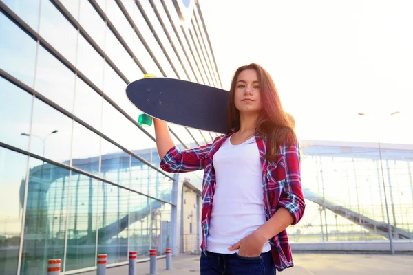 Hermosa joven con un monopatín — Foto de Stock