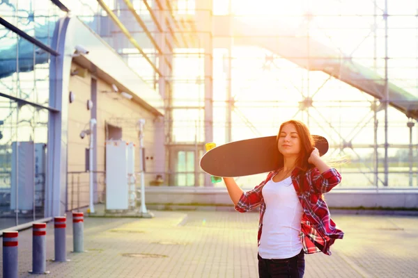 Bella giovane donna con uno skateboard — Foto Stock