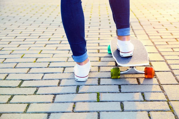 Patineta piernas de niña y tabla de cerca — Foto de Stock