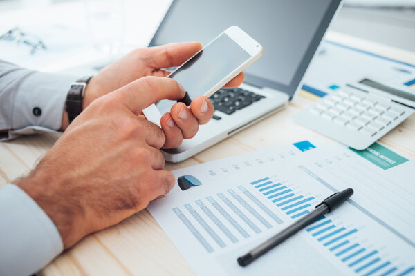 Бизнесмен с помощью финансового приложения
