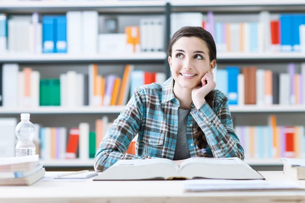 Chica sonriente en la biblioteca — Foto de Stock