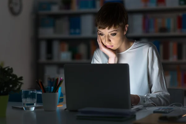 Mulher usando um laptop tarde da noite — Fotografia de Stock