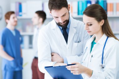 Doktorlar hastanın tıbbi kayıtları kontrol ofiste