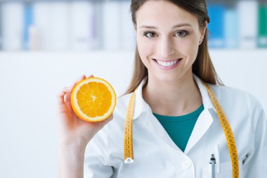 Nutritionist holding a sliced orange clipart