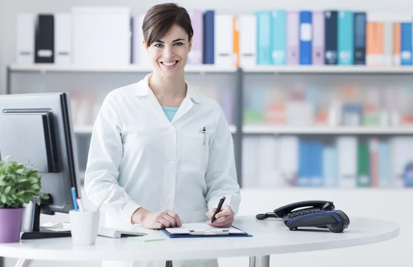 Uśmiechnięta kobieta lekarz pracuje w klinice — Zdjęcie stockowe
