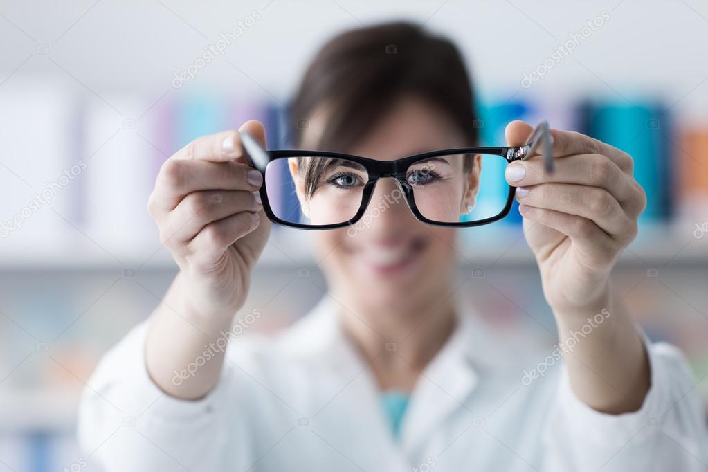 Optometrist giving glasses to the patient