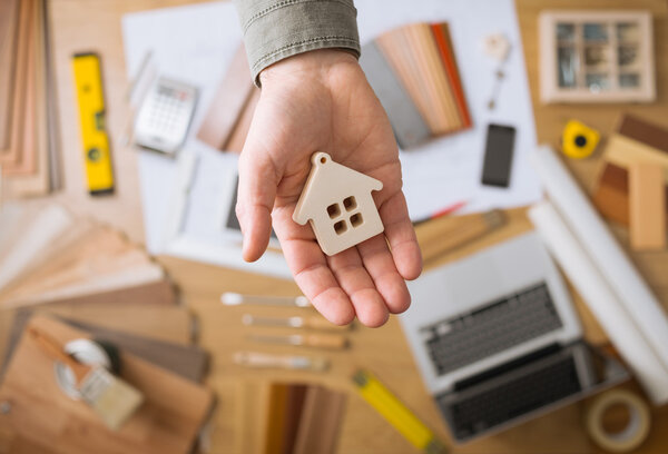 Концепция жилья: Агент по недвижимости держит небольшой дом
