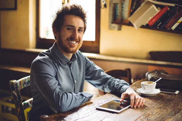 Vrolijke hipster sociale netwerken met zijn Tablet PC — Stockfoto