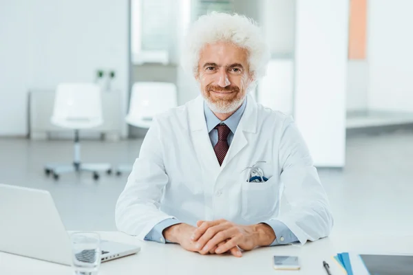 Arzt posiert am Schreibtisch — Stockfoto