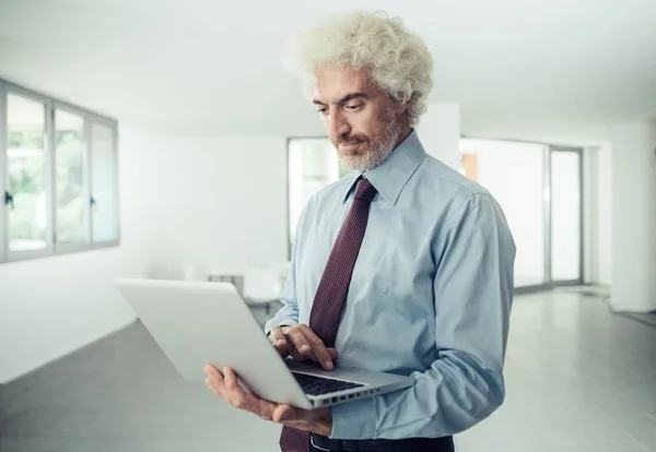 Confident businessman holding a laptop — Stock Photo, Image