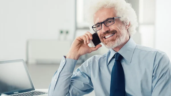 Uomo d'affari sorridente al telefono — Foto Stock