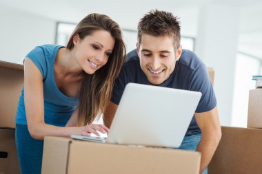 Çift yeni evinde bir dizüstü bilgisayar kullanarak