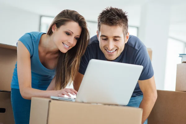 Couple using a laptop in their new house — Stock Photo, Image