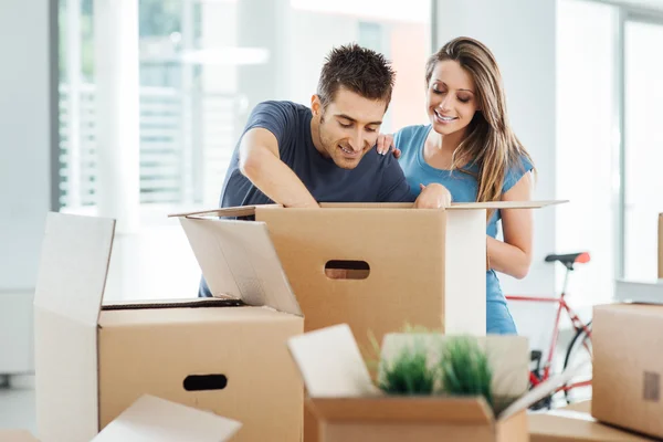 Lachende paar verplaatsen in een nieuw huis — Stockfoto