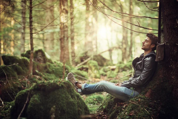 Jonge man rust in het bos — Stockfoto