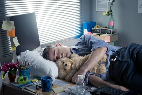 Büroangestellte schläft bei der Arbeit mit Teddybär — Stockfoto