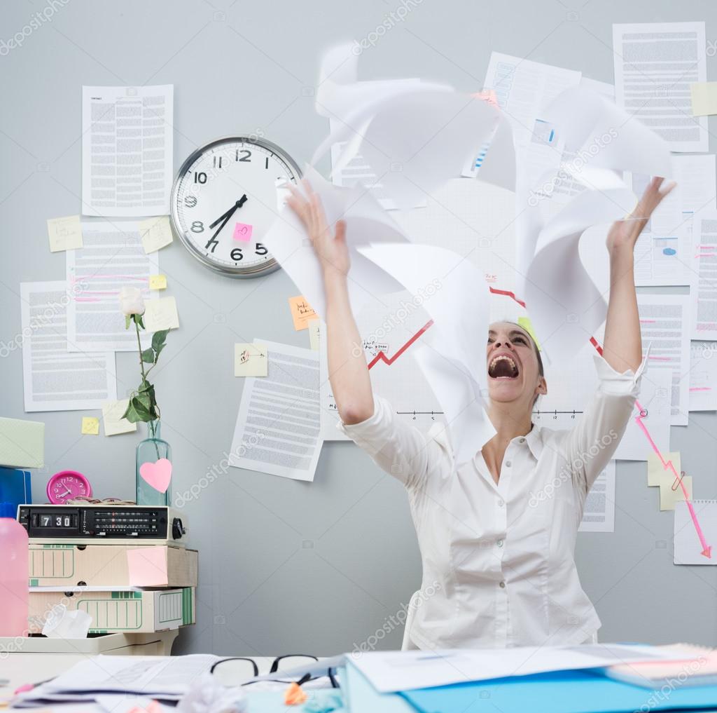 Angry businesswoman throwing paperwork in air