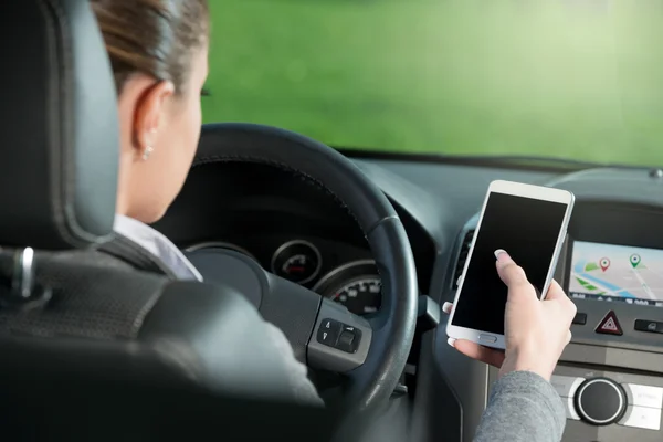 Conductor utilizando el teléfono inteligente y la navegación GPS en un coche —  Fotos de Stock