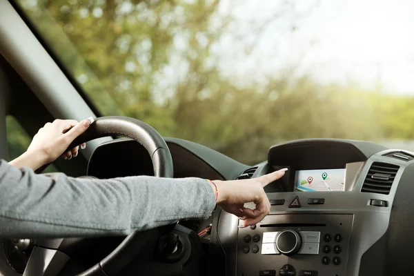 Vrouw met behulp van gps navigator in een auto — Stockfoto