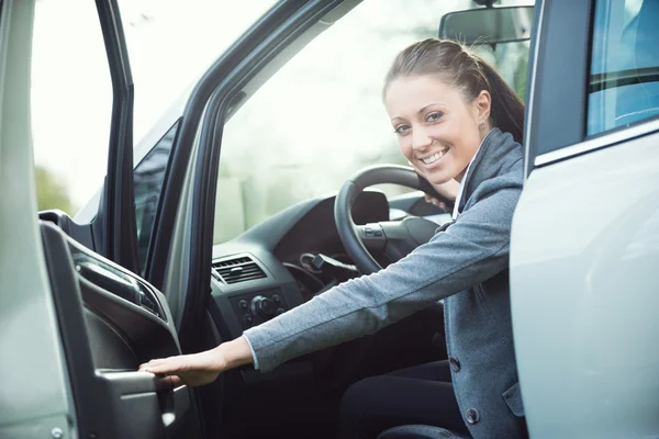 Jovem mulher abrindo porta do carro — Fotografia de Stock