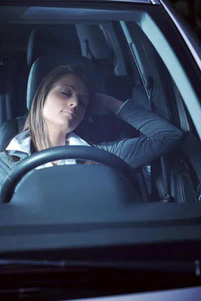 Uitgeput vrouw slapen in een auto — Stockfoto