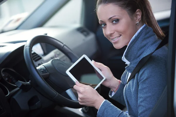 Donna sorridente in macchina con tablet — Foto Stock
