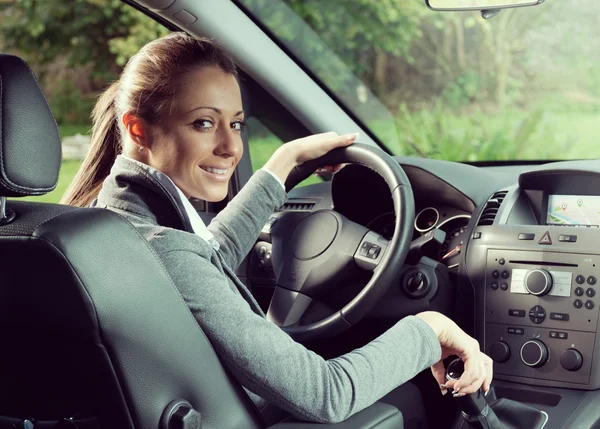 Smiling woman driving and looking at camera Royalty Free Stock Images