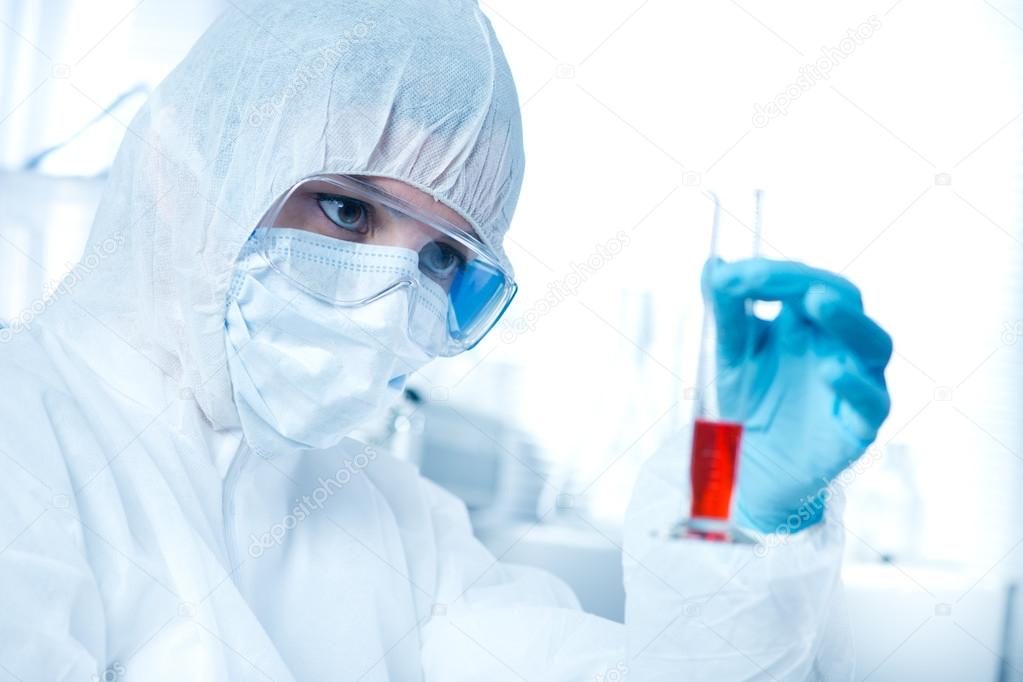 Researcher in hazmat suit with test tube