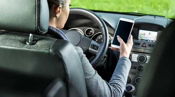 Conductor utilizando el teléfono inteligente y la navegación GPS en un coche —  Fotos de Stock
