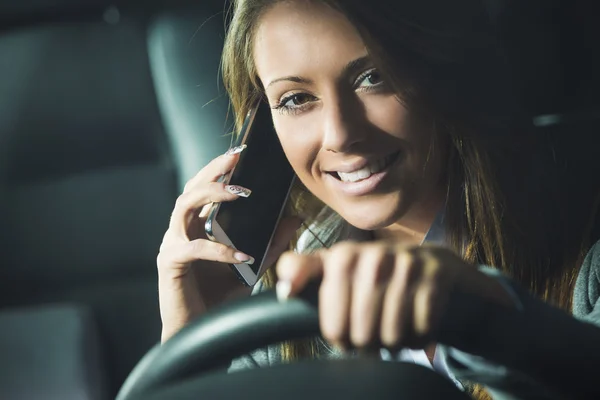 Femme conducteur souriante au téléphone — Photo