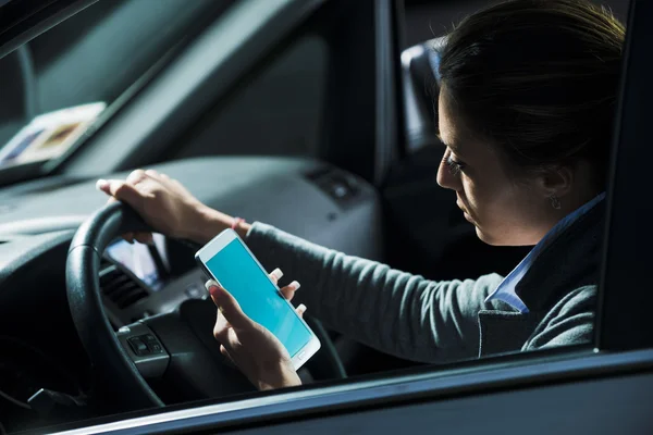 Frau benutzt Handy während der Fahrt — Stockfoto