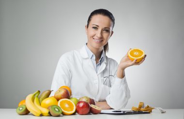 Dietician holding an orange clipart