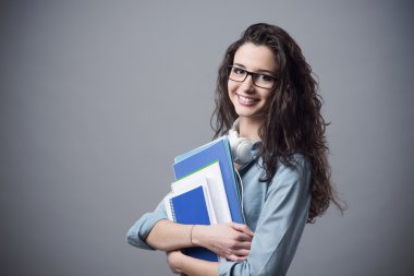 Beautiful student girl posing with notebooks clipart