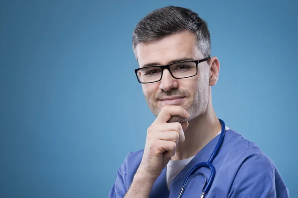 Médico sonriente con la mano en la barbilla — Foto de Stock