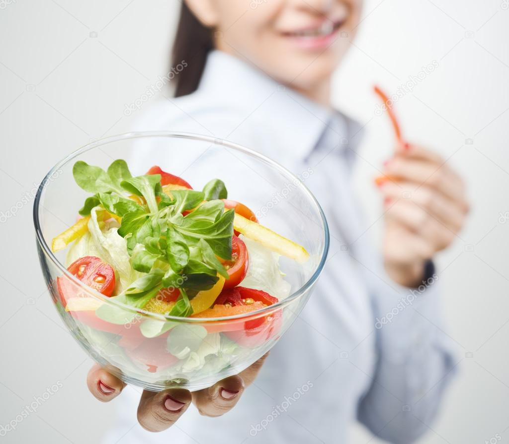 Cheerful woman eating salad