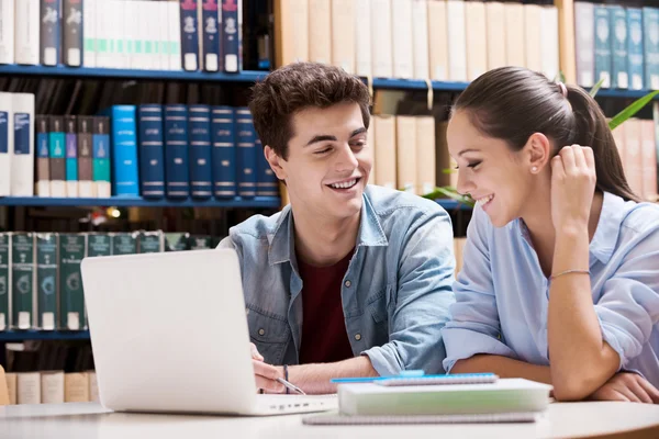 Jonge studenten in de bibliotheek — Stockfoto