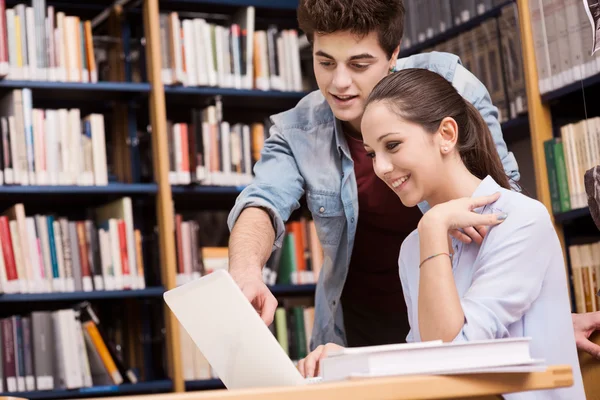 Compañeros de escuela estudiando juntos en la biblioteca —  Fotos de Stock