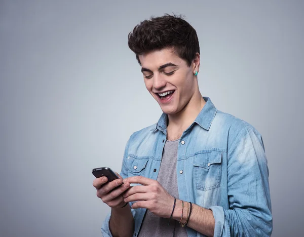 Ragazzo sorridente sms con smartphone — Foto Stock