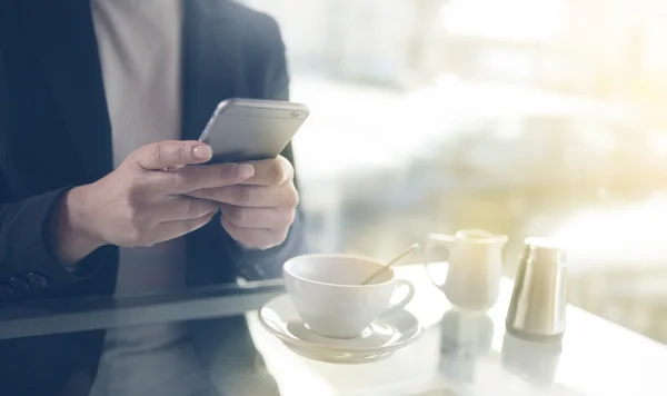 Empresária enviando mensagens com seu celular durante uma pausa para o café — Fotografia de Stock