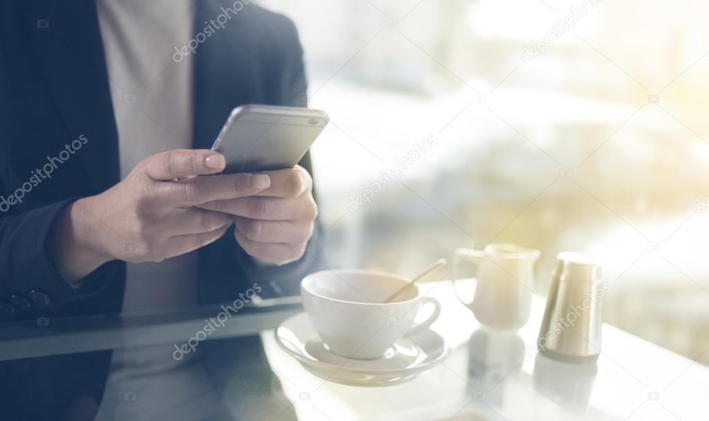 Businesswoman texting with her mobile during a coffee break