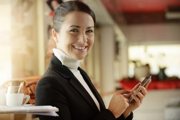 Femme au bar textos avec son téléphone portable — Photo