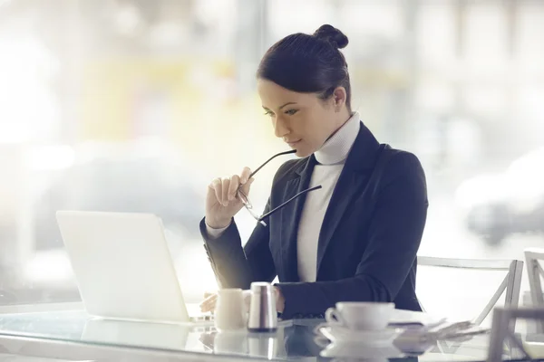 Upptagen kvinna som arbetar på sin laptop — Stockfoto