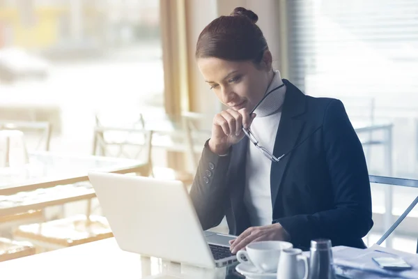 Donna d'affari fiduciosa che lavora su un computer portatile — Foto Stock