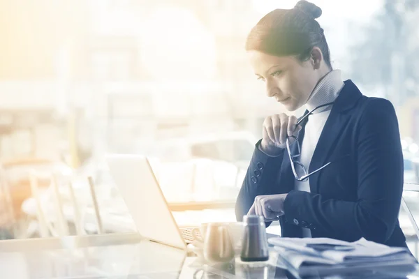 Drukke vrouw die met haar laptop werkt — Stockfoto