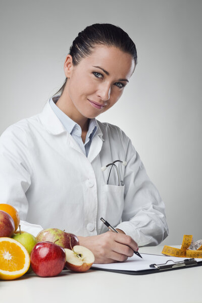 Smiling nutritionist writing medical records