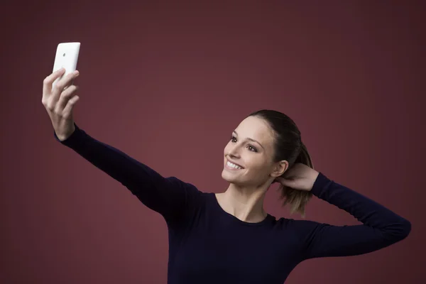 Femme souriante prenant un selfie — Photo