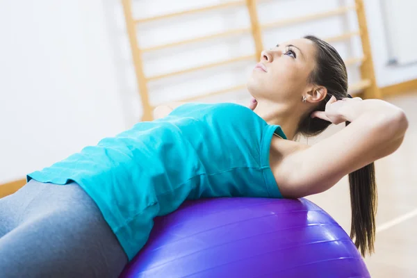 Mulher atraente exercitando com bola de fitness — Fotografia de Stock